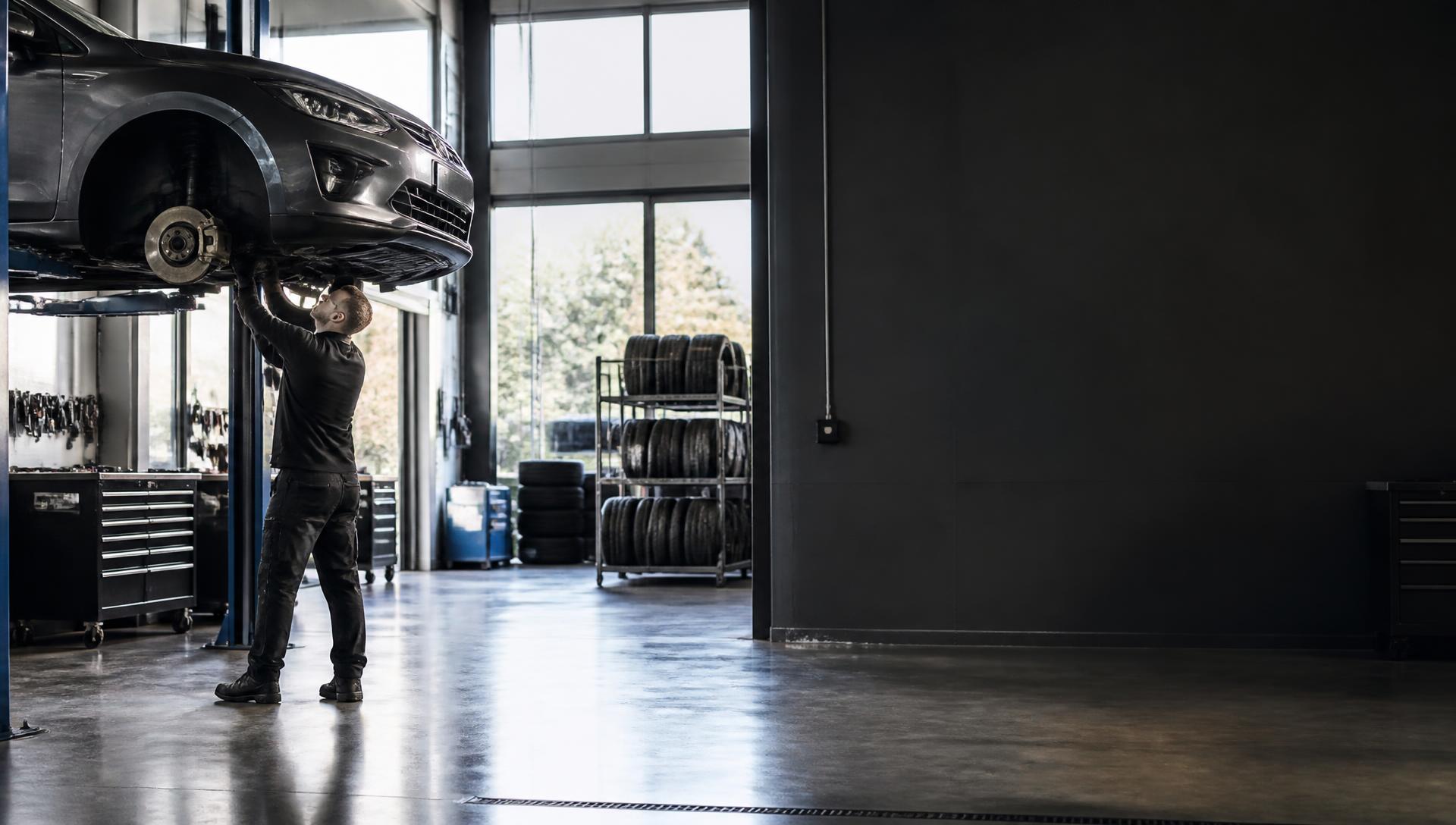 Mechanik AUTO IMBA při opravě vozu na zvedáku